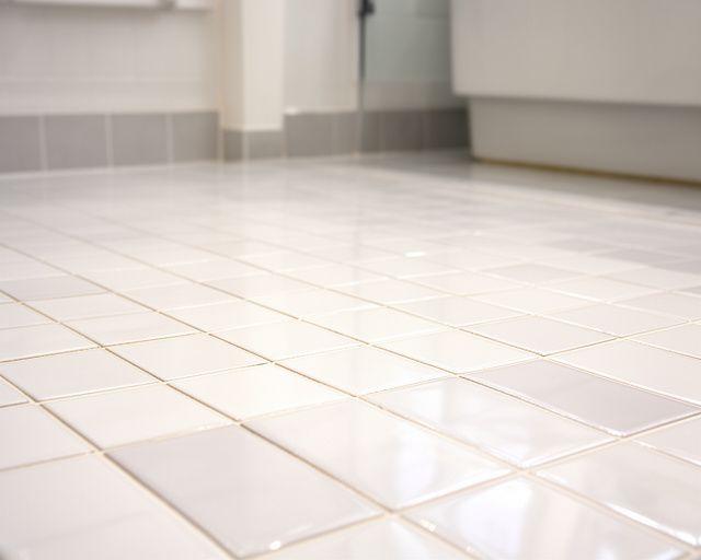 Polished bathroom tile with bright grout and revived shine after restoration in a Brooklyn brownstone